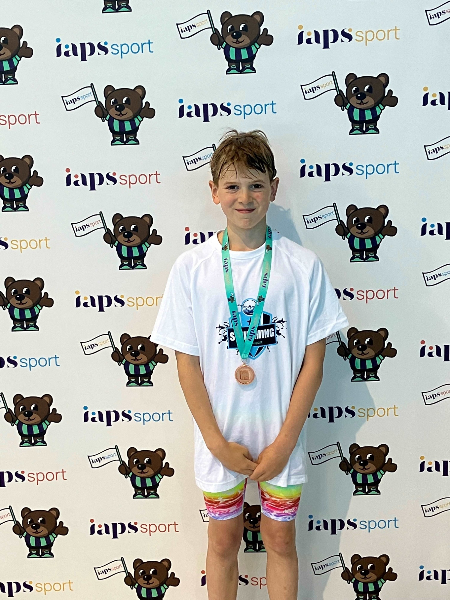 Izaak poses with his bronze medal from U11 breaststroke finals
