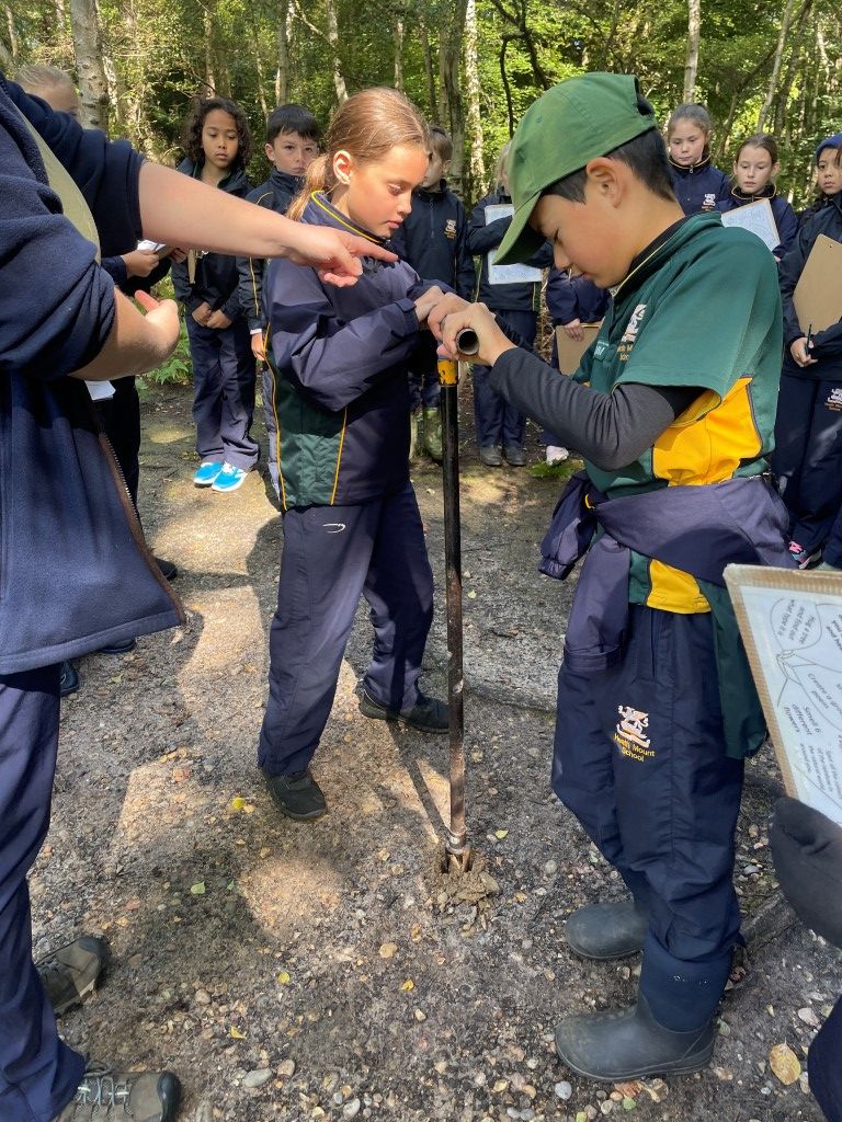 two children drill into the ground to get a soil sample at Epping Forest fieldwork centre