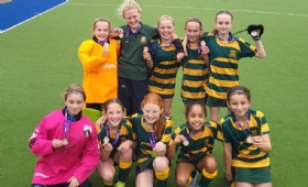 U11 hockey team pose with their gold medals at the U11 IAPS hockey finals