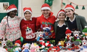 Senior Craft club girls pose behind some of the Christmas decorations being sold at our charity fair