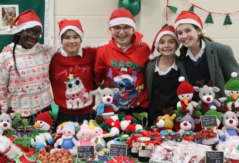 Senior Craft club girls pose behind some of the Christmas decorations being sold at our charity fair